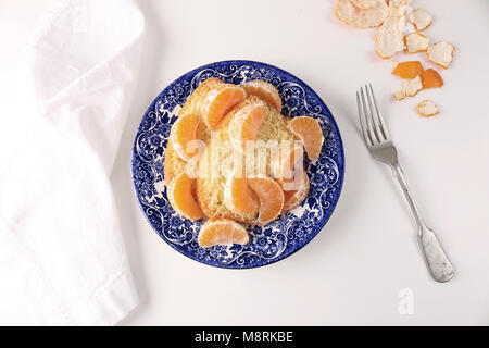 Close-up of sweet bread with oranges in plate over white background Stock Photo
