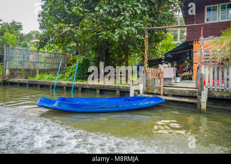 Outdoor view of blue plastic small boat at the riverside at yai canal or Khlong Bang Luang in Thailand Stock Photo