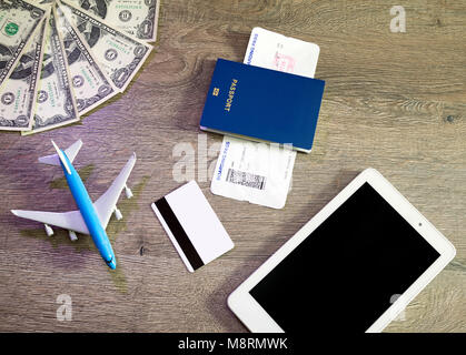 Preparation for Traveling concept, airplane, laptop, boarding pass, passport, credit card, on vintage wooden background. Stock Photo
