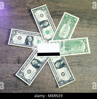 Blank White Credit Card with magnetic strip over lies on one Dollars Stock Photo