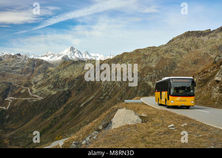 FURKAPASS, SWITZERLAND - OCTOBER 2017 - Typical yellow Postbus in Switzerland on high altitude Furka pass road. The highest point of road reaches 2429 Stock Photo