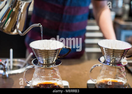 Barista pouring boiling water into coffee filter at cafe Stock Photo