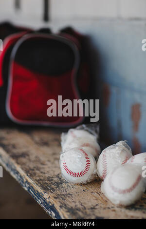 Close-up of baseball balls on wooden table in sports dugout Stock Photo