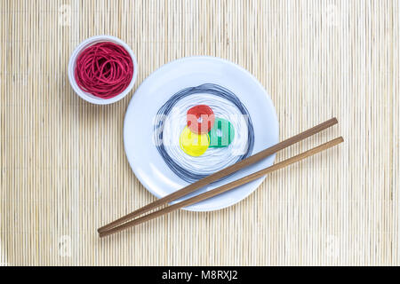 Japanese sushi with soy sauce made from colorful threads and chopsticks on bamboo straw mat background minimal creative concept Stock Photo