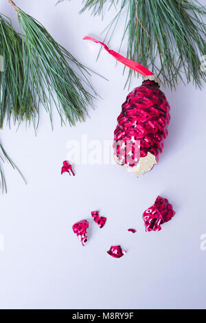 Close-up of broken christmas Decoration with pine needles over white background Stock Photo