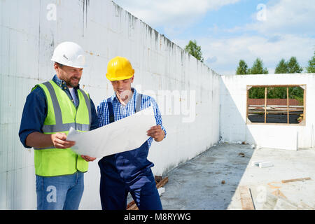 Construction Worker Discussing Floor Plans with Supervisor Stock Photo
