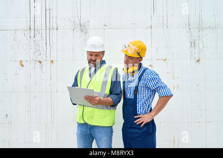 Construction Workers Discussing Building Stock Photo