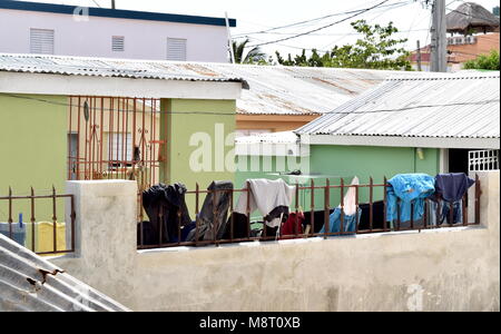 Washed clothes hanging on the wash line attached with colourful pegs. Stock Photo