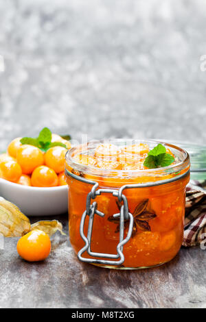 Homemade  physalis jam in jar on wooden table Stock Photo