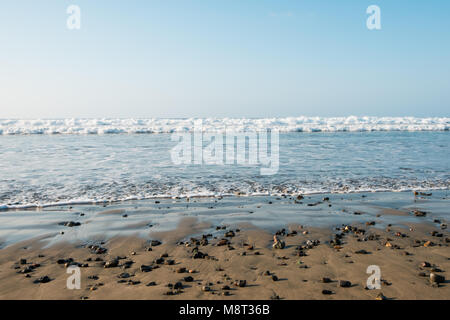 beach landscape - sand, stones, water and blue sky - Stock Photo