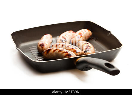 Grilled  sausages in a frying pan isolated on white Stock Photo