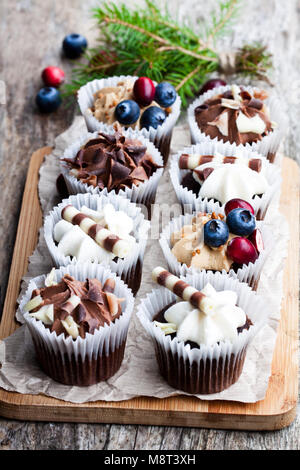Chocolate  mini cupcakes with christmas decoration on wooden table Stock Photo