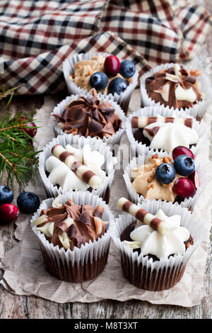 Chocolate  mini cupcakes with christmas decoration on wooden table Stock Photo