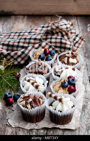 Chocolate  mini cupcakes with christmas decoration on wooden table Stock Photo