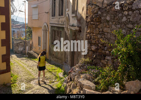 Woman tourist travel in sun hat and glasses on summer vacations walking in old city Alacati,Cesme,Turkey Close up portrait,funny face Stock Photo