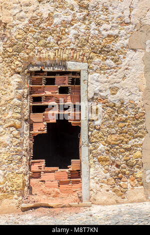 Old front wall with sealed stony door Stock Photo