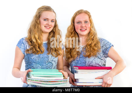 Two school pupils holding pile of textbooks isolated on white