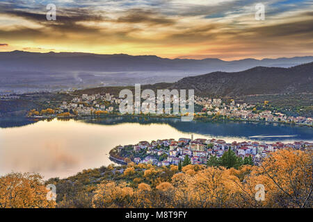 Panoramic view of Kastoria city reflected on the tranquil surface of Orestiada lake with autumn colors, in West Macedonia, Northern Greece Stock Photo