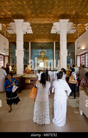 Local people and pilgrims praying and giving flower gifts at the Jaya Sri Maha Bodhi temple in Anuradhapura, Sri Lanka. Stock Photo