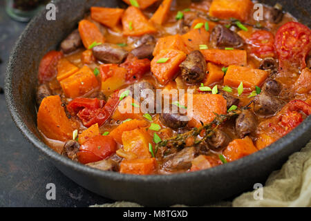Chicken hearts with pumpkin and tomatoes in tomato sauce. Stock Photo