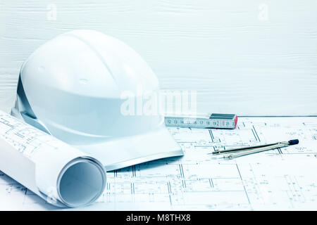engineering project plans, blueprints, protective helmet, folding ruler and compasses on table. architects workplace closeup. Stock Photo
