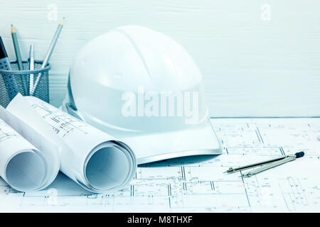 architects drawing tools and instruments, helmet, blueprint rolls on engineering project drawing. construction concept background. Stock Photo