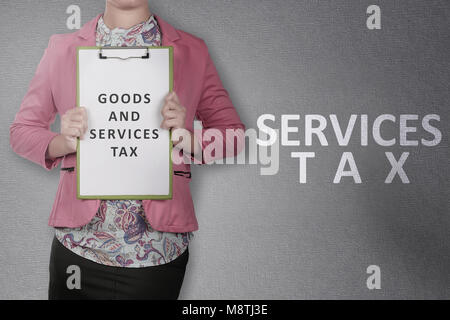 Business woman showing clipboard with Goods and services tax text. Goods and services tax concept Stock Photo