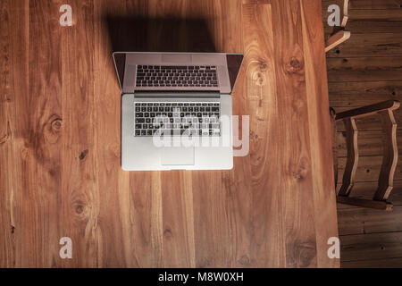 wooden desk in the office, laptop on it, view from above Stock Photo