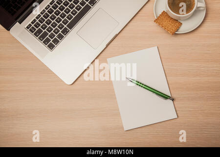 an empty notebook on a corporate desk, coffee and cookie next to it Stock Photo