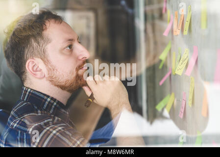 Creative businessman writing notes on paper in office Stock Photo