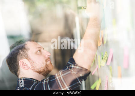 Creative businessman writing notes on paper in office Stock Photo