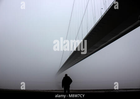 Humber Bridge with Fog,  one Man looking out to the river, Yorkshire, England, UK Stock Photo