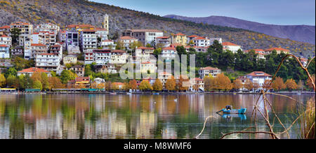 Panoramic view of Kastoria city reflected on the tranquil surface of Orestiada lake with autumn colors, in West Macedonia, Northern Greece Stock Photo