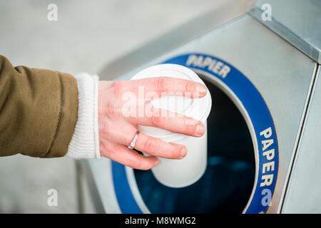 Woman using waste separation container throwing away coffee cup made of Styrofoam Stock Photo