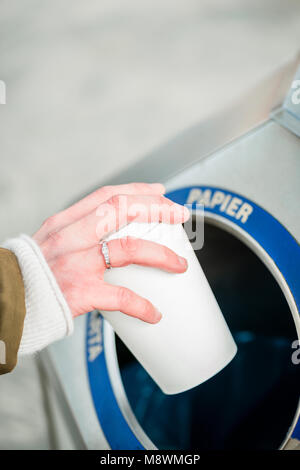 Woman using waste separation container throwing away coffee cup made of Styrofoam Stock Photo