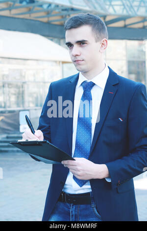 close up. businessman making notes on the clipboard Stock Photo