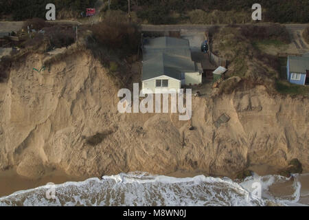 Houses sit on the cliff edge on The Marrams in Hemsby, Norfolk, as thirteen homes on the sandy cliffs have been evacuated amid fears they could topple into the sea, with a further two days of high tides and strong winds forecast. Stock Photo