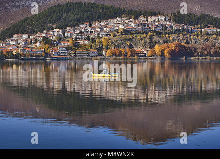 Panoramic view of Kastoria city reflected on the tranquil surface of Orestiada lake with autumn colors, in West Macedonia, Northern Greece Stock Photo