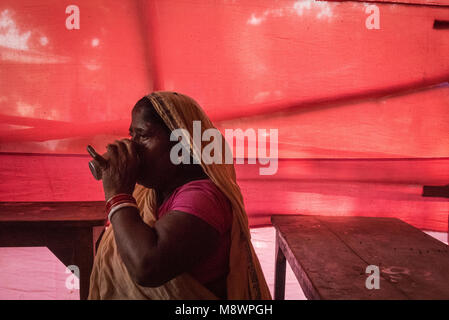 A woman drinks a cup of tea at a refeshment stand, Sonepur Mela, Sonepur, India. Stock Photo