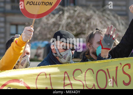 Glasgow, UK. 20th Mar, 2018. A protester looks at photographers camera during a protest in Glasgow's George Square in front of Glasgow City Council as he stands behind a sign that reads ''Glasgow's Kids Need Clean Air!'' at an Anti-Pollution demonstration against GCC's Low Emission Zone Plans will fail to tackle toxic air pollution quickly enough. Credit: Stewart Kirby/SOPA Images/ZUMA Wire/Alamy Live News Stock Photo