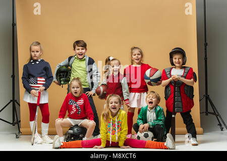 Group of happy children show different sport. Studio fashion concept. Emotions concept. Stock Photo