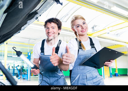Mechanic team working in car workshop Stock Photo