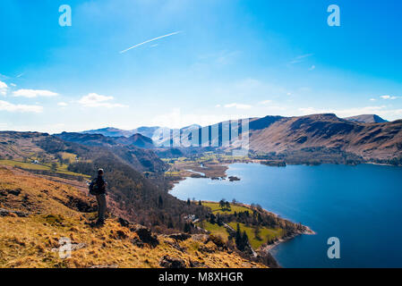 Walker looking over Derwent Water and Borrowdale from above Falcon Crag in the English Lake District Stock Photo