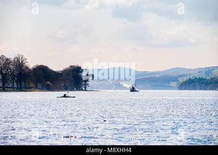 Kayaker and the National Trust-owned restored steam yacht Gondola on Coniston Water in the English Lake District Stock Photo