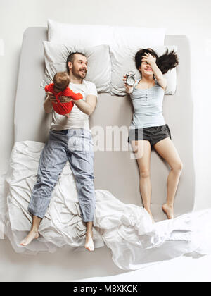Top view of happy family with one newborn child in bedroom. Stock Photo
