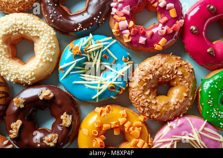 Various colorful donuts on blue background, top view Stock Photo