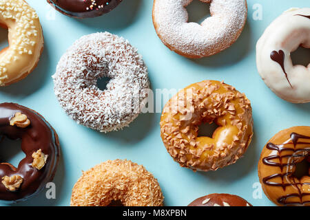 Various colorful donuts on blue background, top view Stock Photo