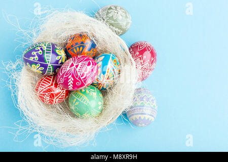 Colorful shiny easter eggs in wicker basket Stock Photo