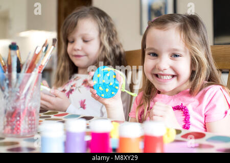 Two Girls Making Easter Decorations At Home Stock Photo