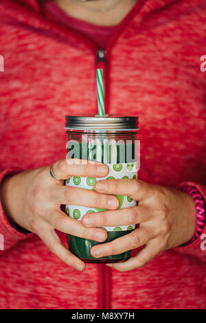 Womans hands holding a green Detox juice Stock Photo